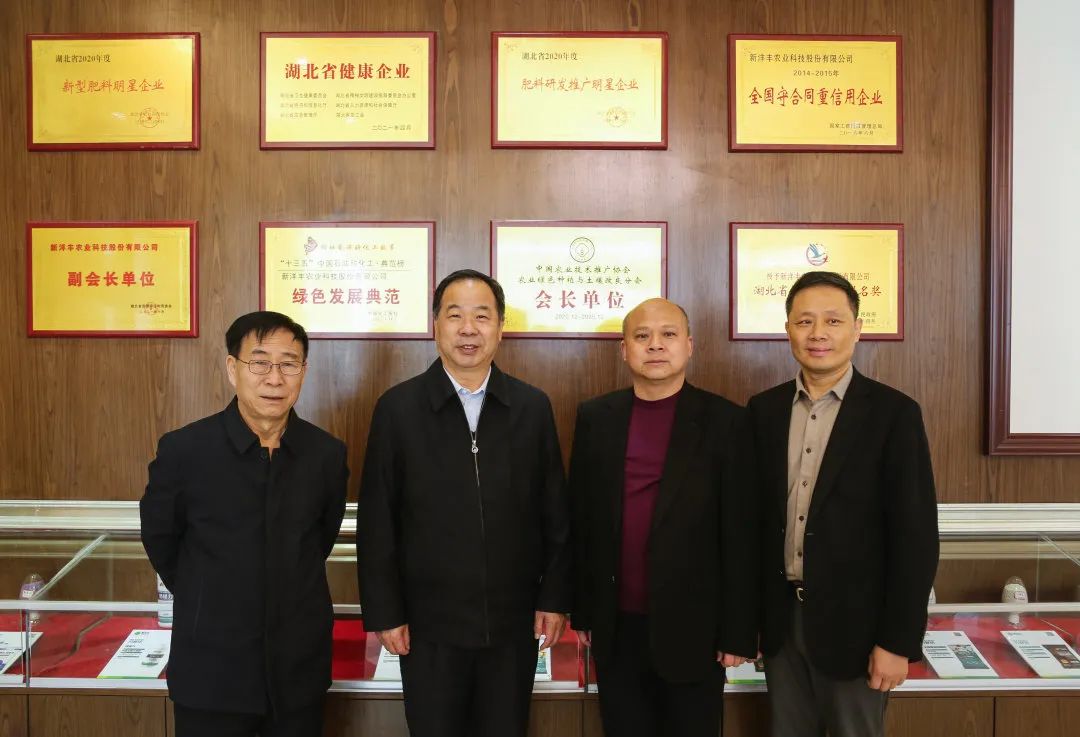 中国农业技术推广协会会长陈生斗（左二）、秘书长张互助（左一），中国农业技术推广协会农业绿色种植与土壤改良分会会长赵程云（右二）、秘书长冯卫东（右一）在新洋丰展厅分会会长单位牌匾前合影.jpg